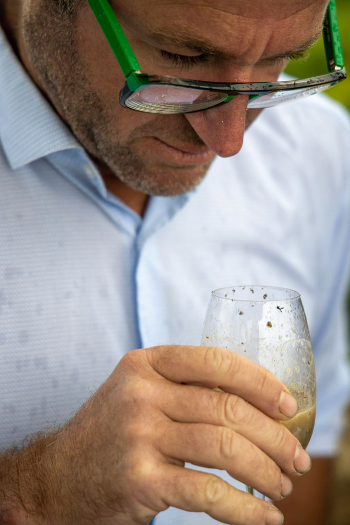 Benoit qui sent un verre de terre - Identité terroir - Agence Discovery