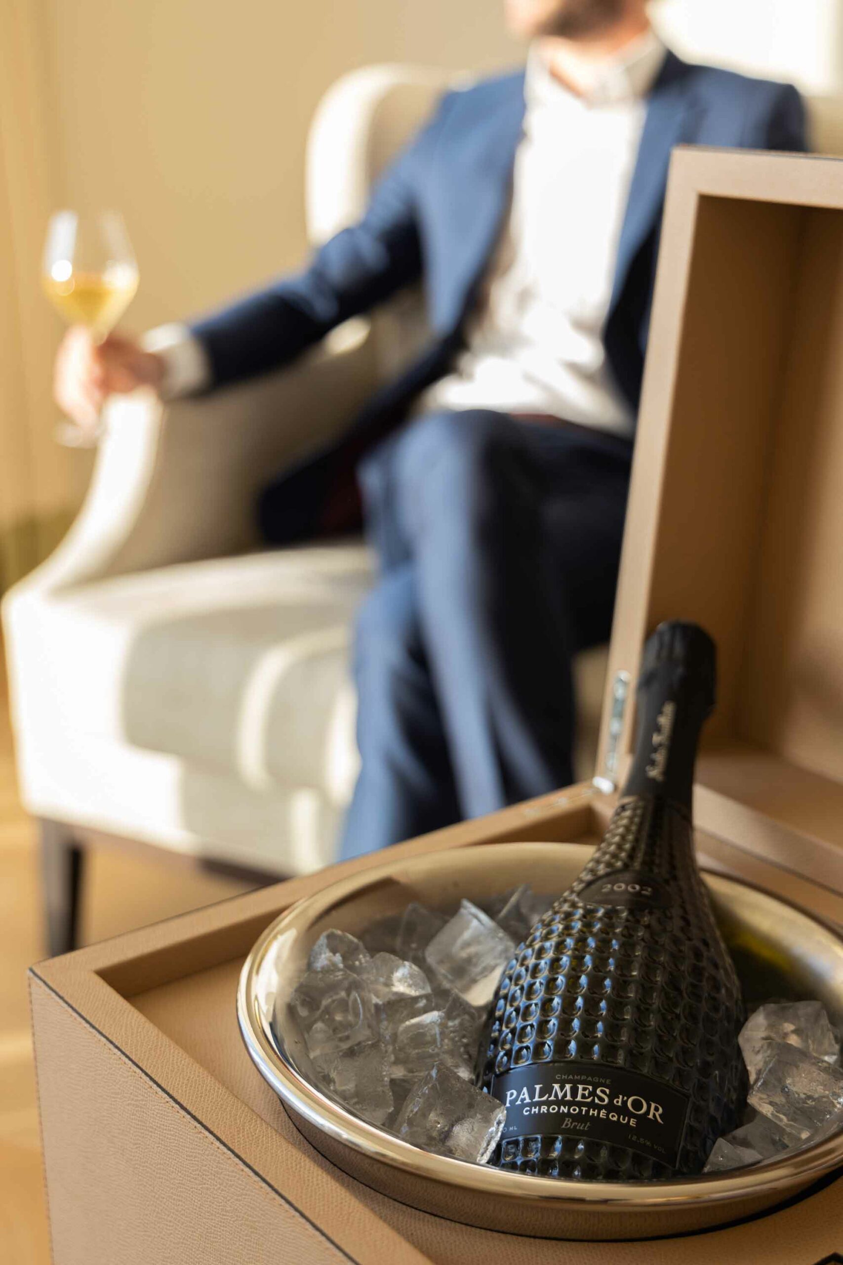Un homme déguste un verre de la cuvée Chronothèque Palmes d'Or Champagne Nicolas Feuillatte dans la chambre du Royal Champagne | Réalisation Agence de communication Discovery